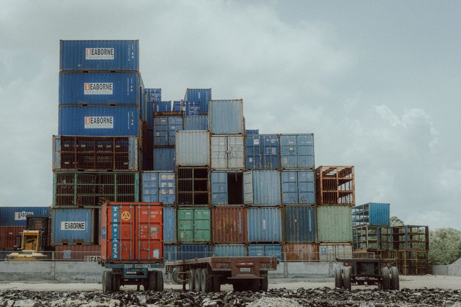 Colorful shipping containers stacked at a port, illustrating global logistics and commerce.